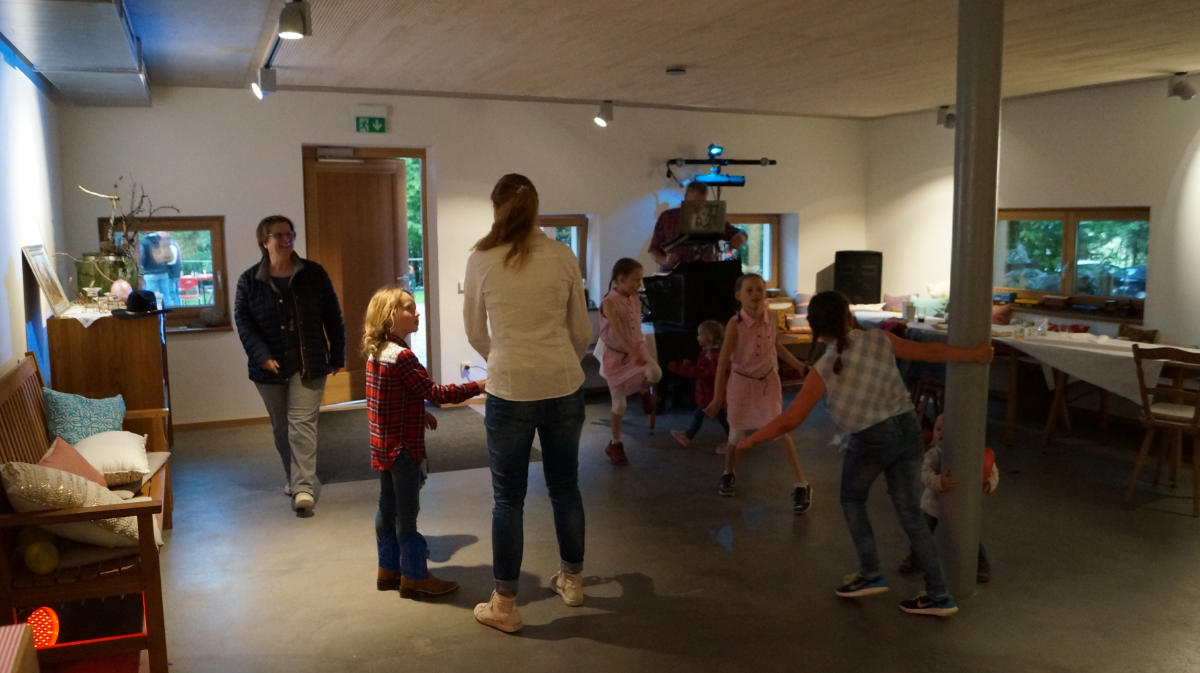 Tanzende Kinder und Erwachsende im kleinen Gastraum